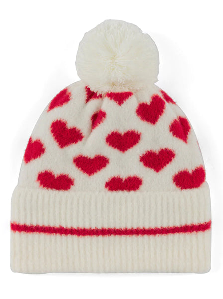 Image features an ivory beanie with a pom-pom and red hearts pattern throughout. 