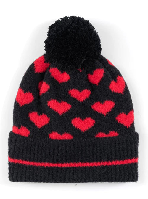 Image features a black beanie with a pom-pom and red hearts pattern throughout. 